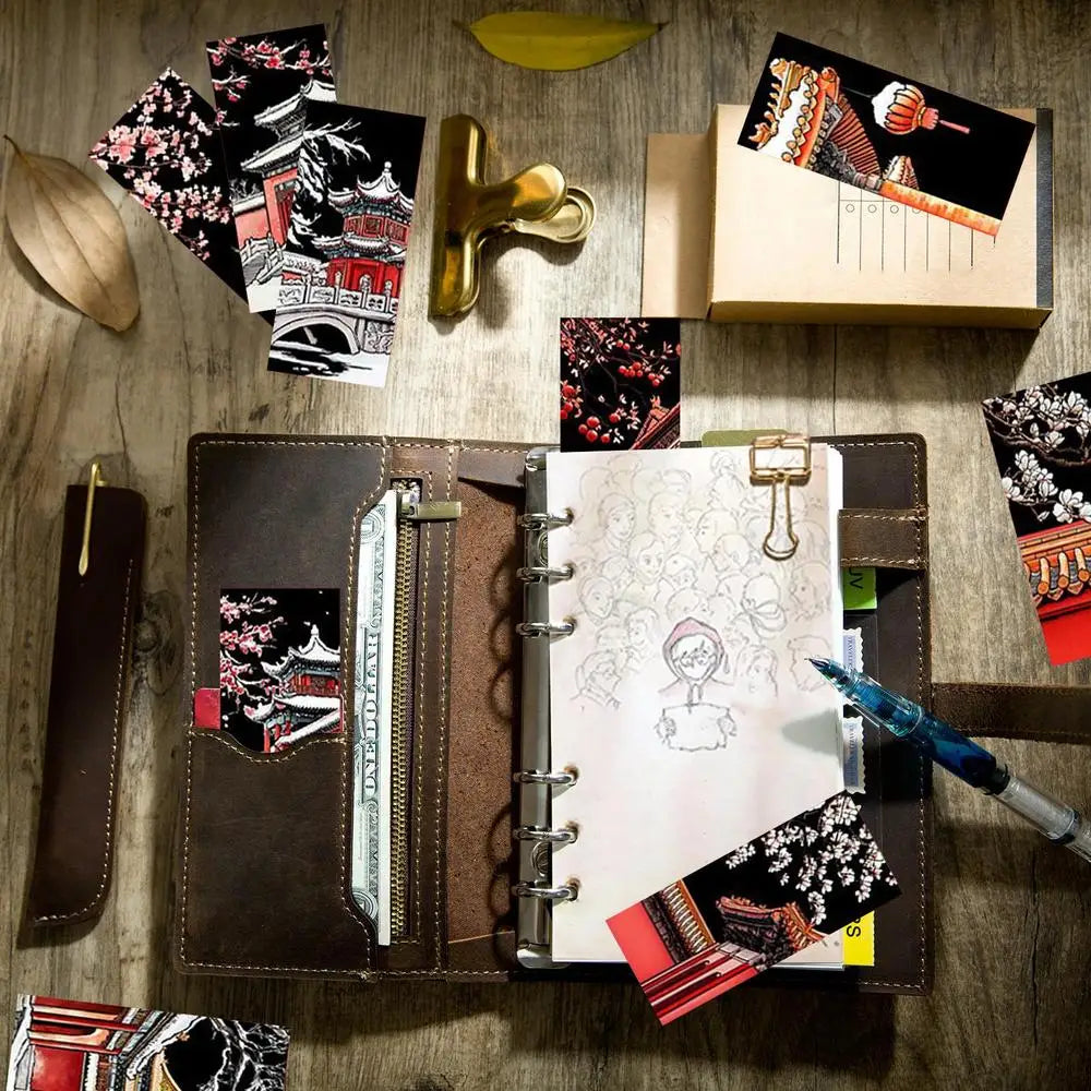 Open notebook with stationery items on a wooden surface