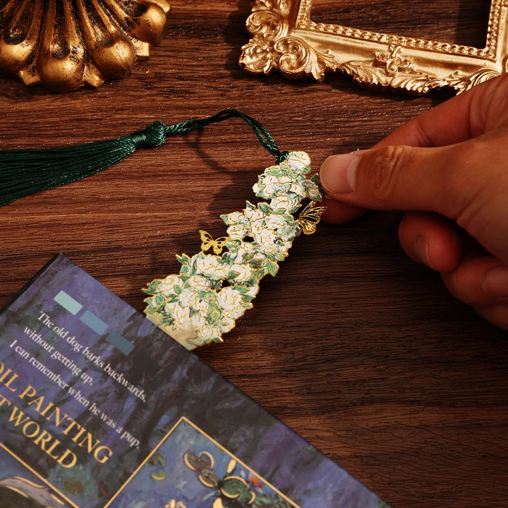 Decorative bookmark with floral design held by a hand on a book