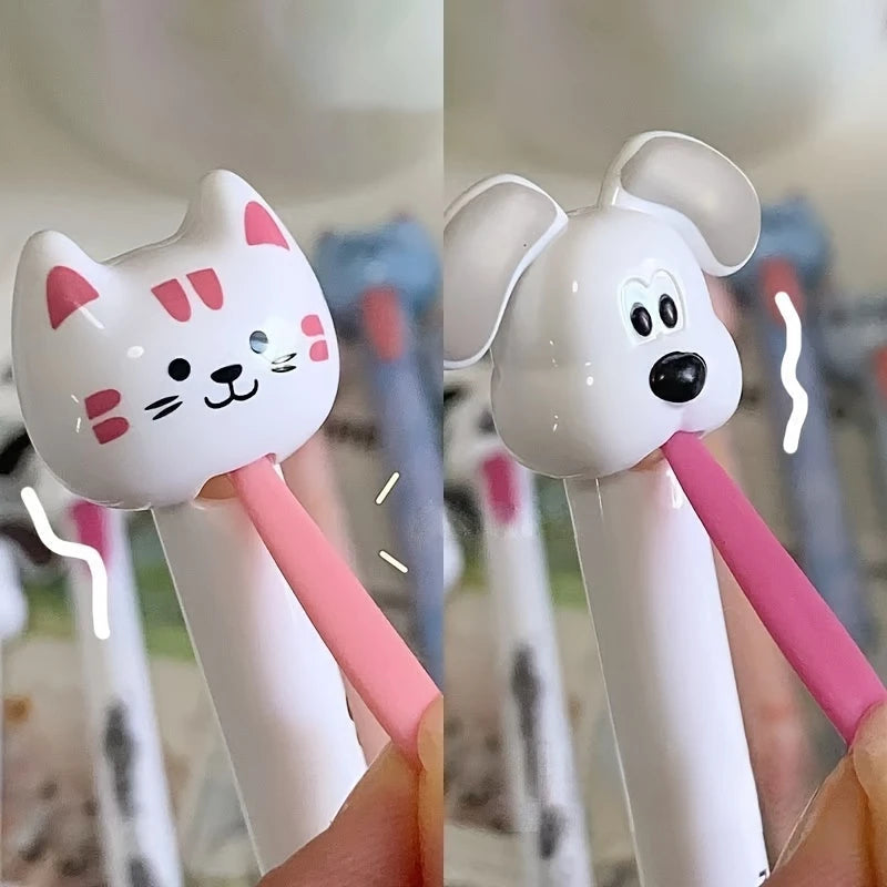 Two cartoon-themed pens, one cat-shaped and one dog-shaped, held in a hand with a blurred background.