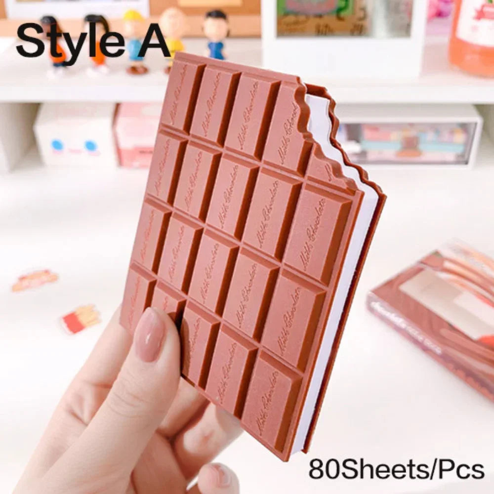 Notebook shaped like a chocolate bar held by a hand with a blurred background