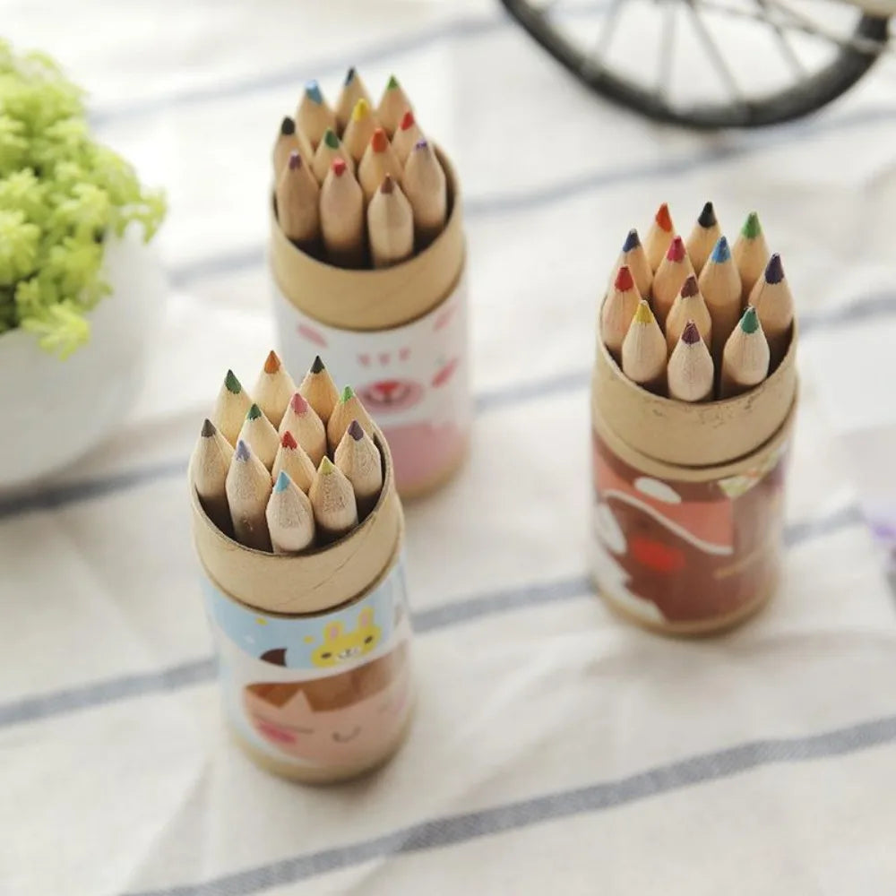 Three small cylindrical containers filled with colored pencils on a striped surface.