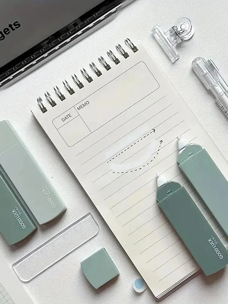 Notebook with stationery items on a light surface