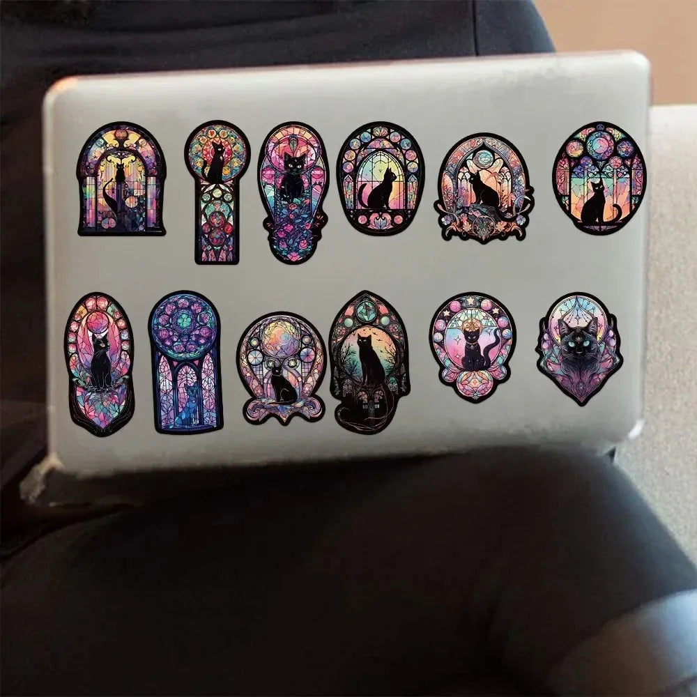 Laptop with decorative stickers of cats in stained glass designs on a neutral background