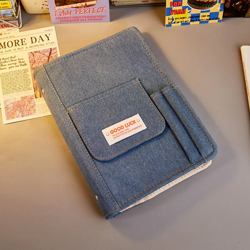 Blue denim notebook with a patch on a gray surface