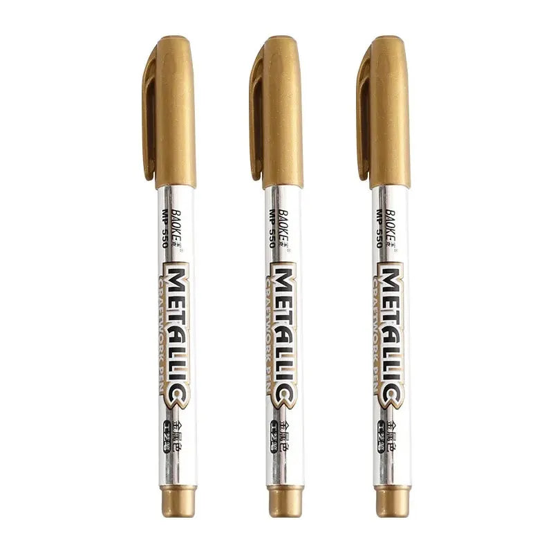 Three gold metallic markers on a white background