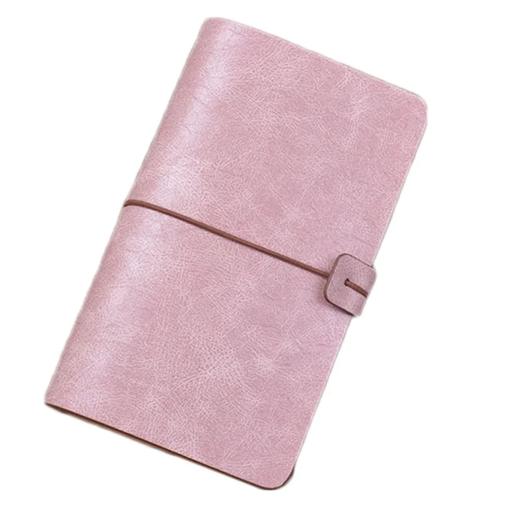 Pink leather-bound notebook with a strap on a white background