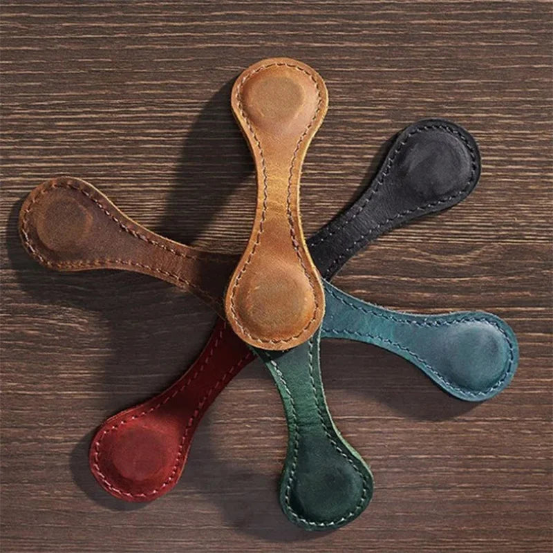Five leather dog toys in different colors arranged in a star pattern on a wooden surface.