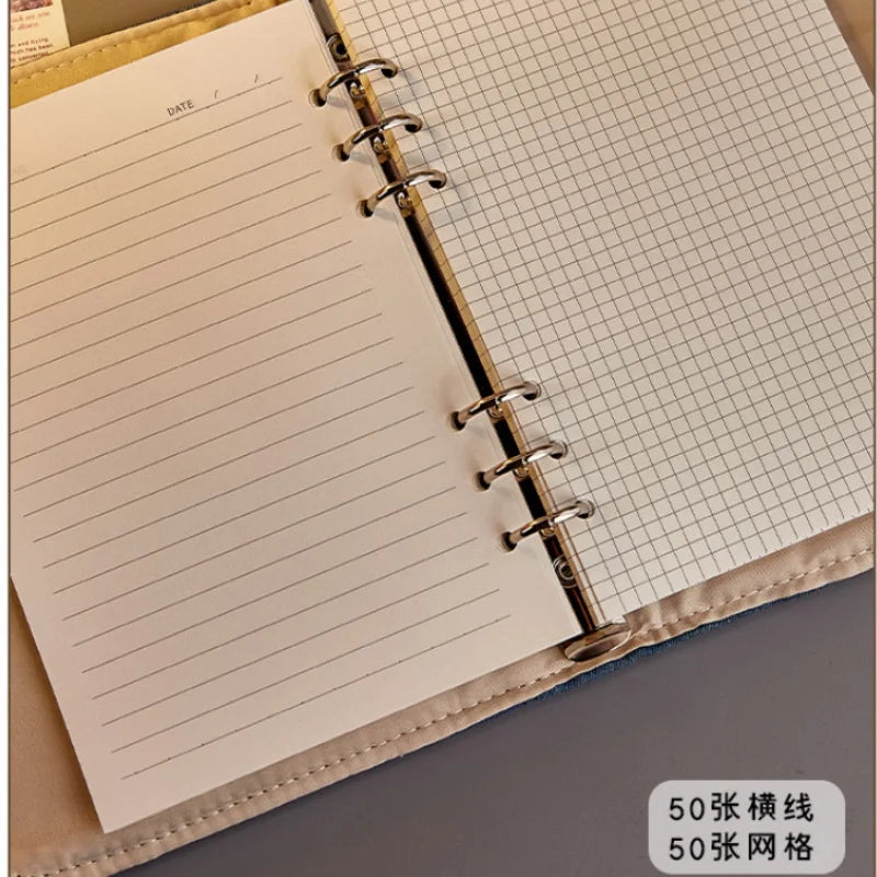 Open notebook with lined and grid pages on a gray surface