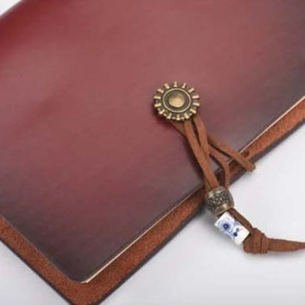 Brown leather-bound book with decorative cord and metal clasp on a white background
