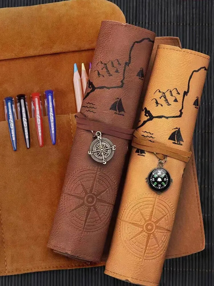 Two brown leather roll-up planners with compasses and embossed designs on a textured surface.