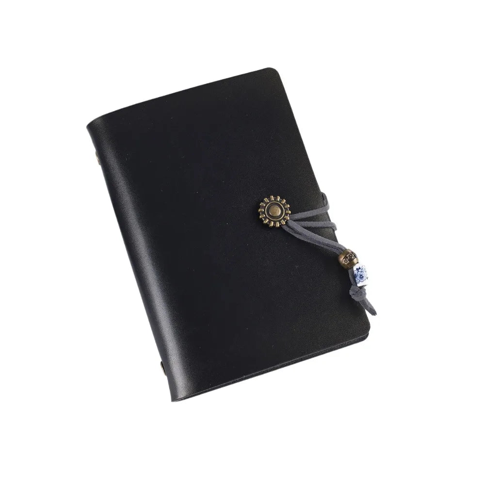 Black leather notebook with decorative clasp on a white background