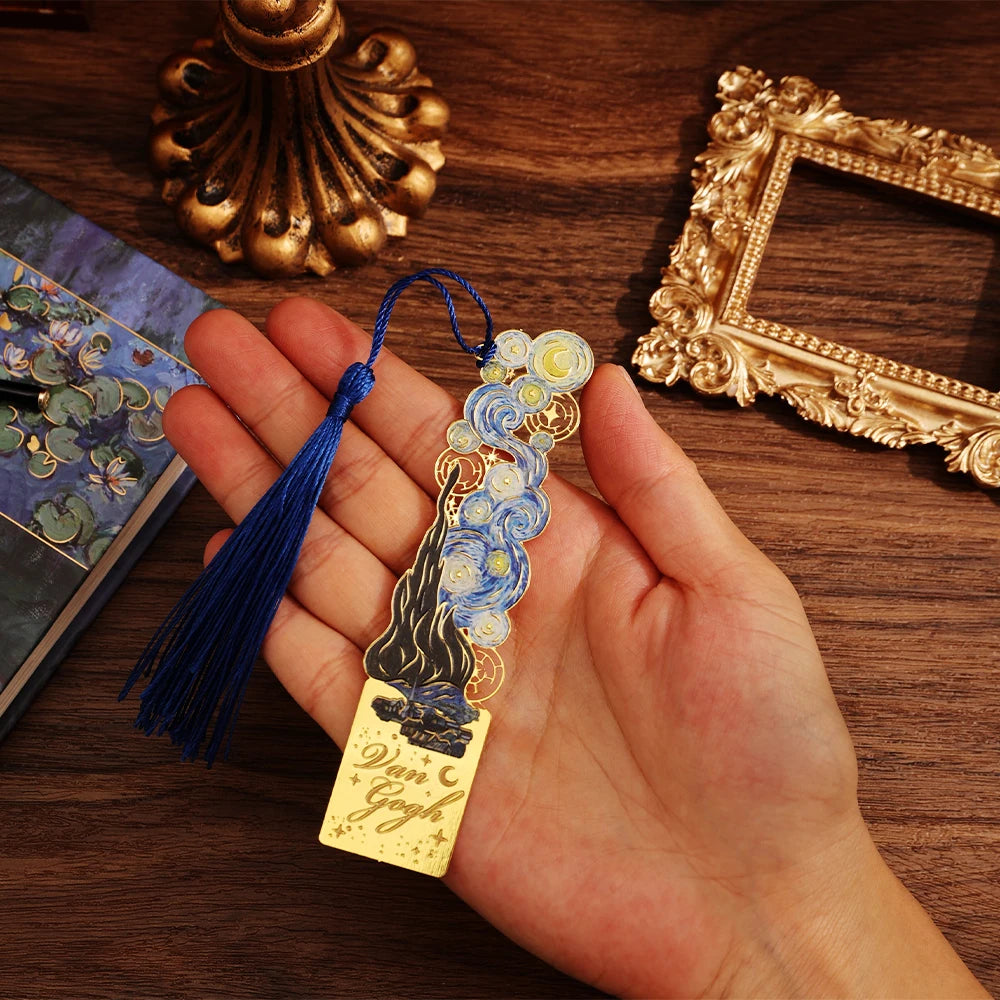 Hand holding a decorative bookmark with tassel on a wooden surface