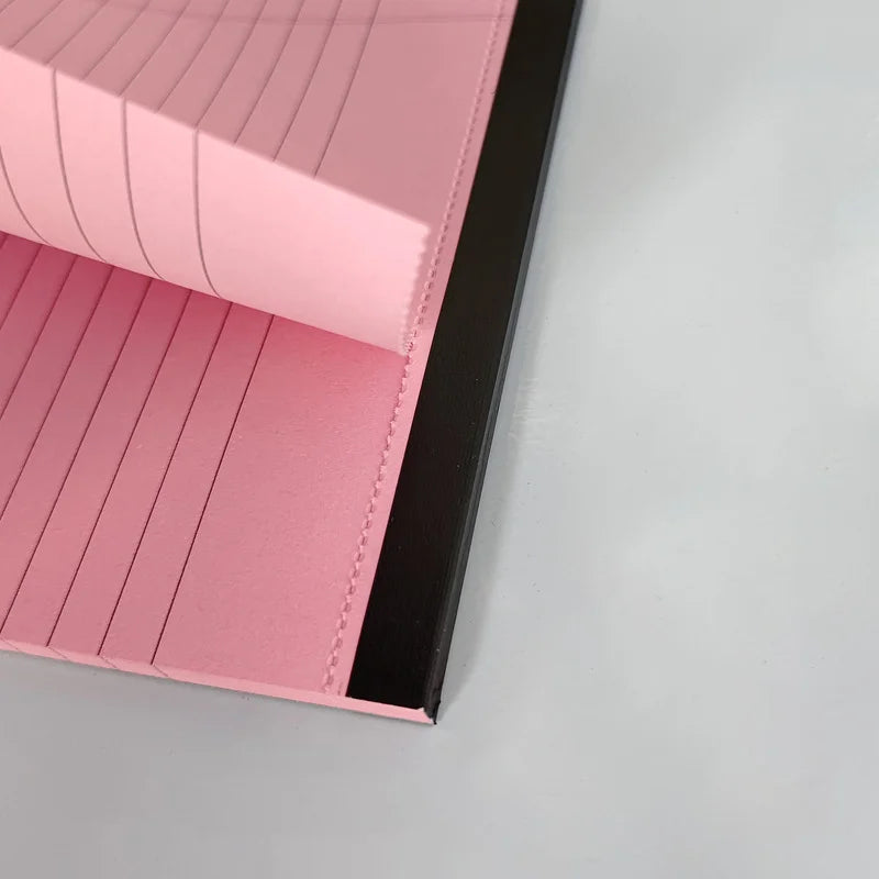 Close-up of a pink leather wallet with black interior on a gray background