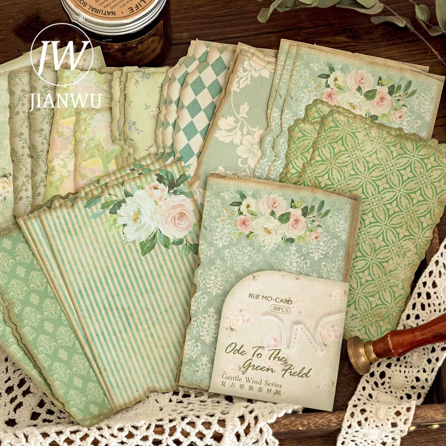 A collection of vintage floral note papers with various floral patterns in shades of green, blue, and white, displayed on a lace doily.