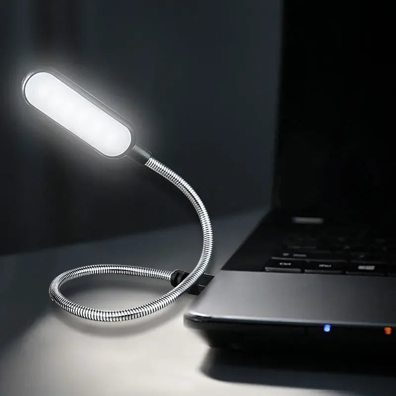 Flexible USB light attached to a laptop on a dark background