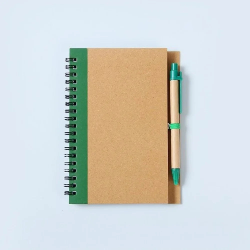 Notebook with green binding and pen on a light blue background