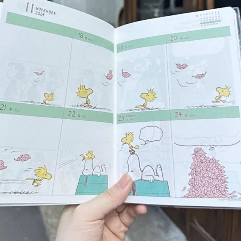 Calendar with cartoon characters held by a hand