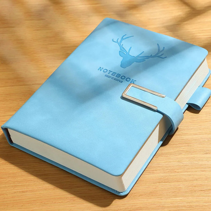 Blue notebook with deer design on a wooden surface