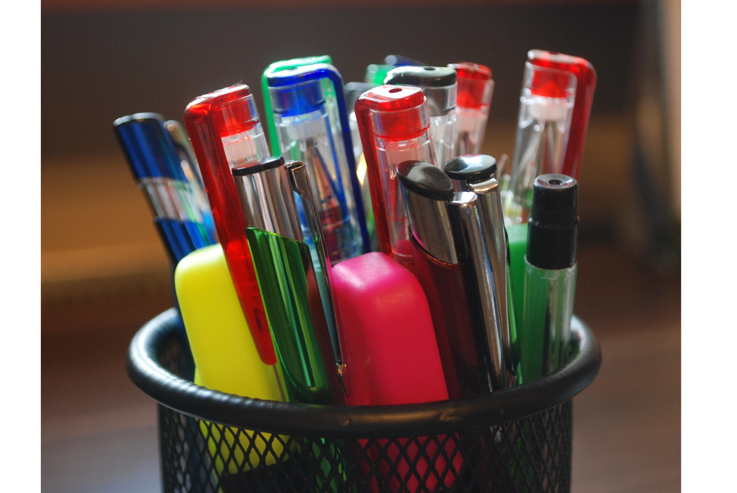 pens and pencils in a mesh container 