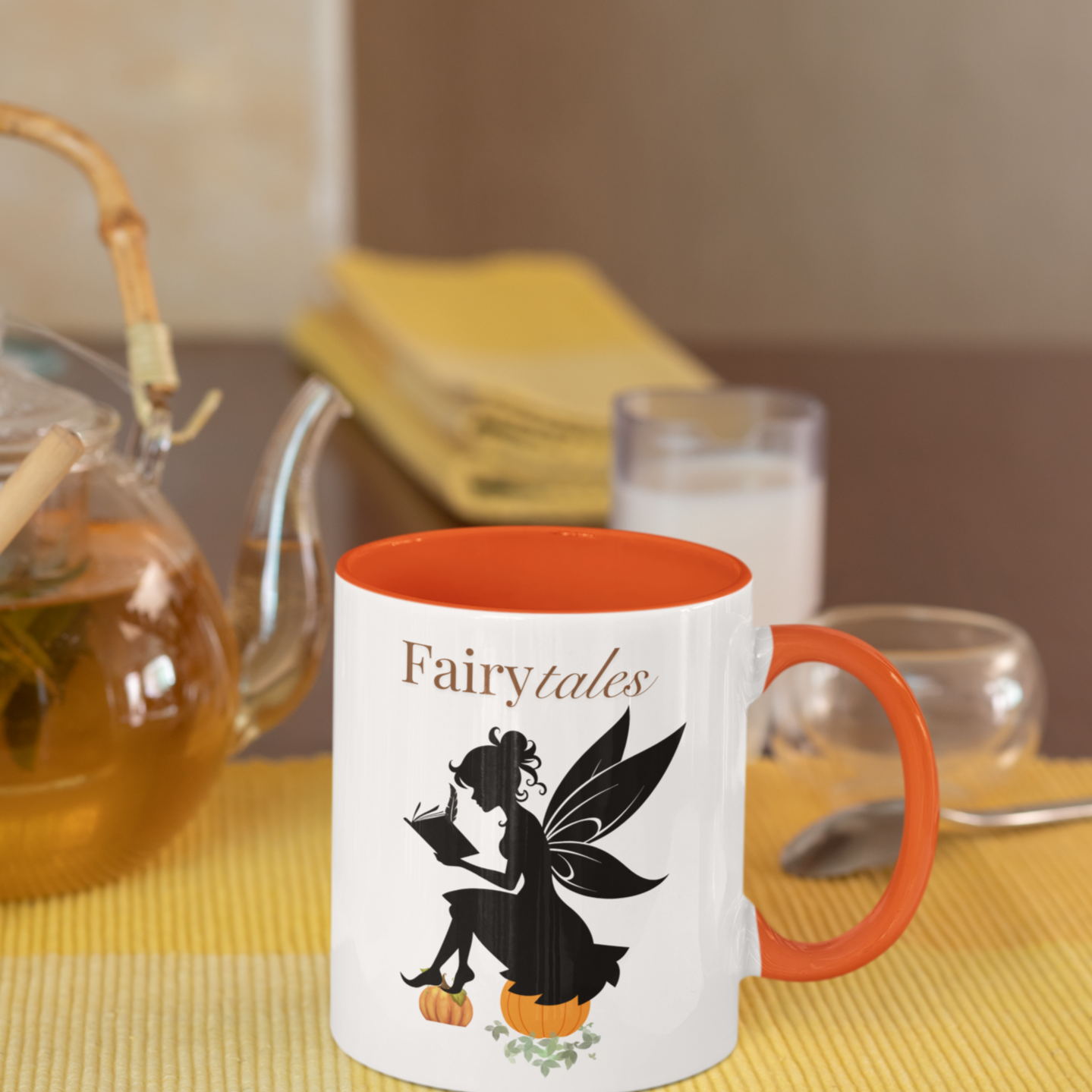 Fairy with wings writing in a book sitting on a pumpkin