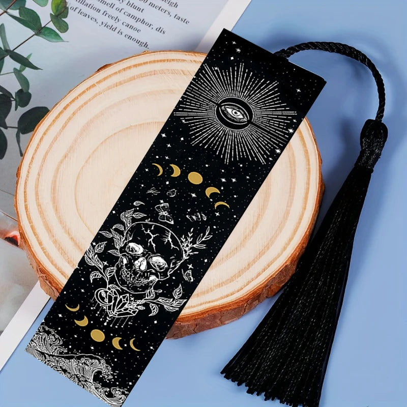 Decorative black bookmark with celestial design on a wooden surface