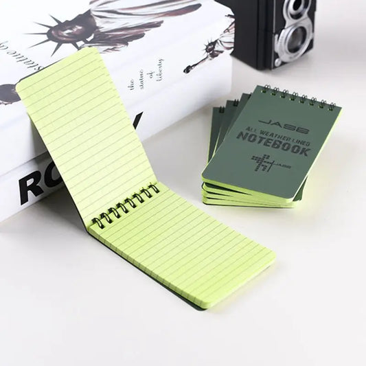 Green spiral-bound notebook with lined pages on a white surface.