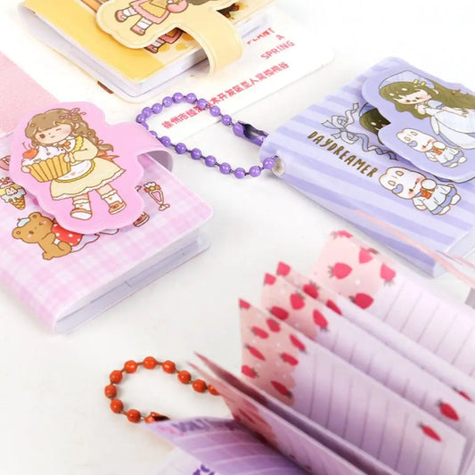 Collection of stationery items including notebooks, bookmarks, and keychains on a white surface.