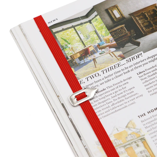Open magazine with a red ribbon bookmark on a white background