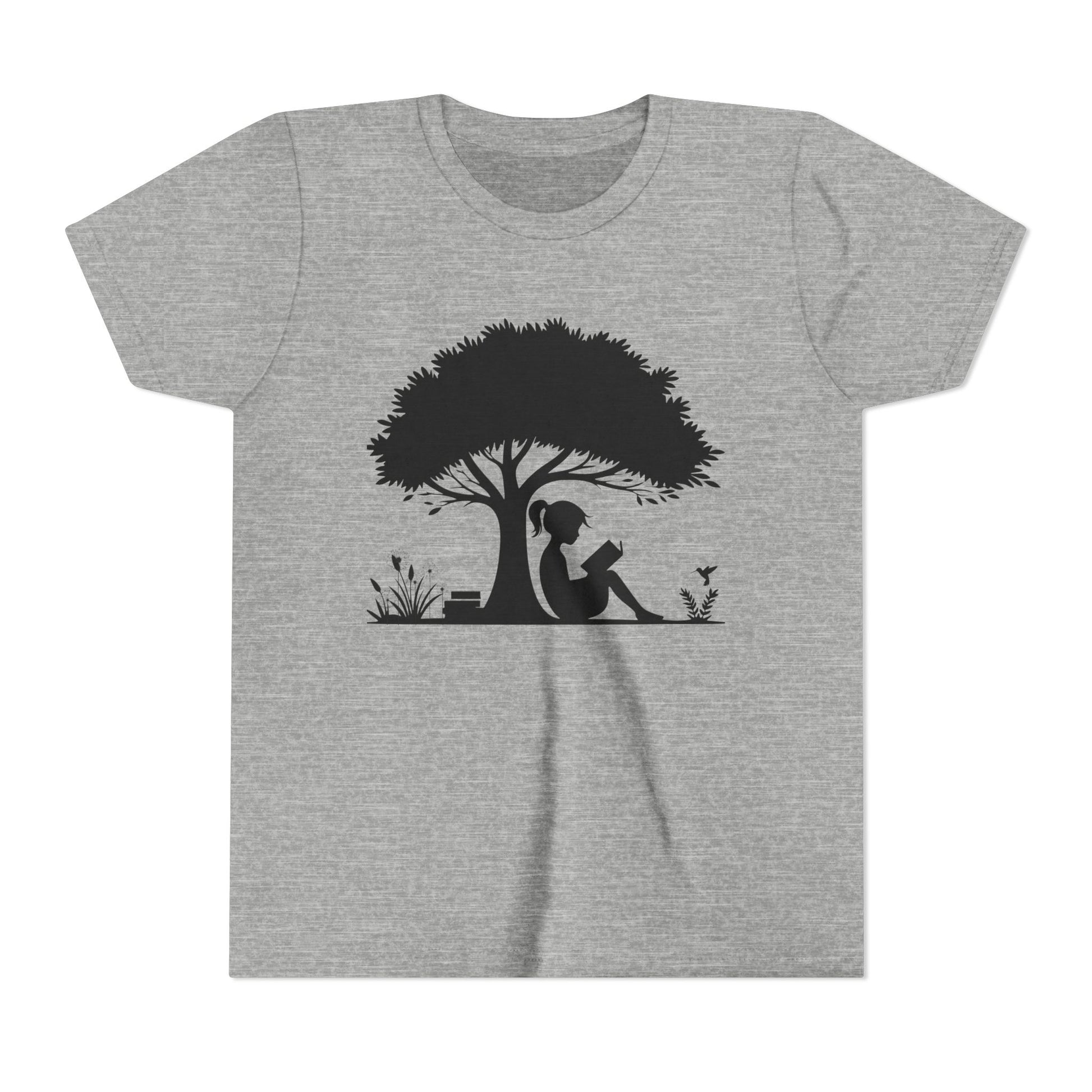 Gray t-shirt with a black silhouette of a girl reading under a tree on a white background