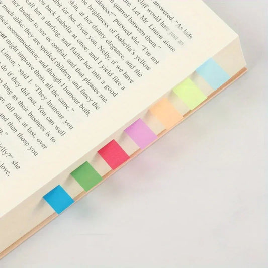 Open book with colorful sticky notes on a white surface