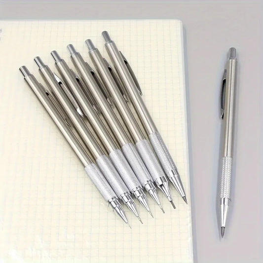 Set of silver pens on a notebook with one pen standing upright.