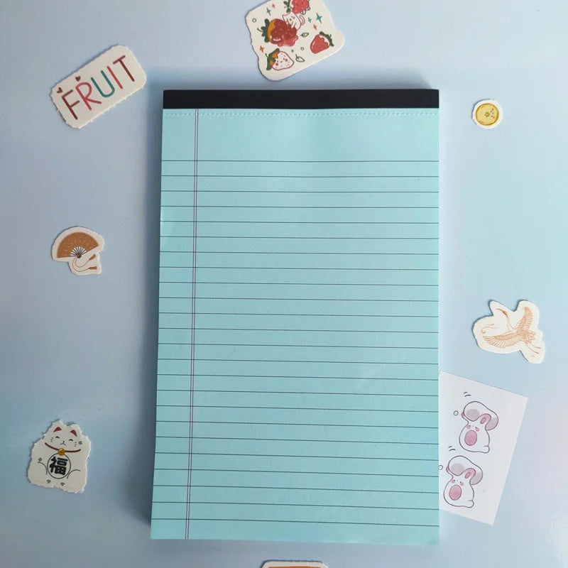 Notepad with lined pages on a light blue background with decorative stickers.