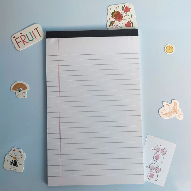 Notebook with lined pages on a light blue background with various stickers around it.