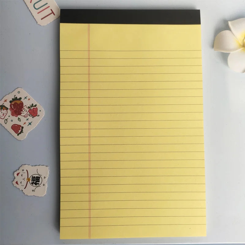 Yellow notepad with red lines on a light gray background