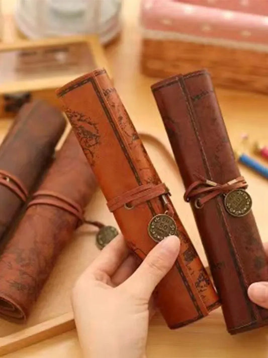 Three brown leather-bound notebooks with decorative elements on a wooden surface.