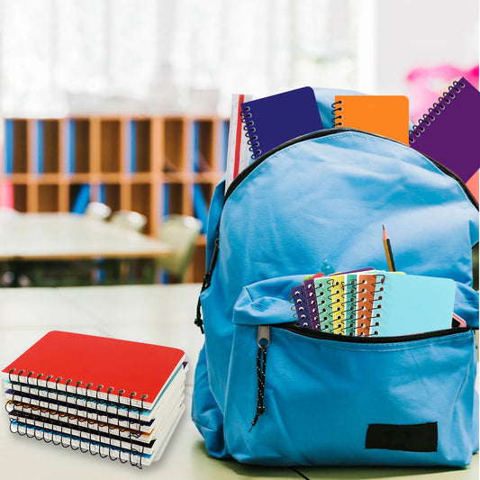 Blue backpack filled with colorful notebooks on a desk in a classroom setting