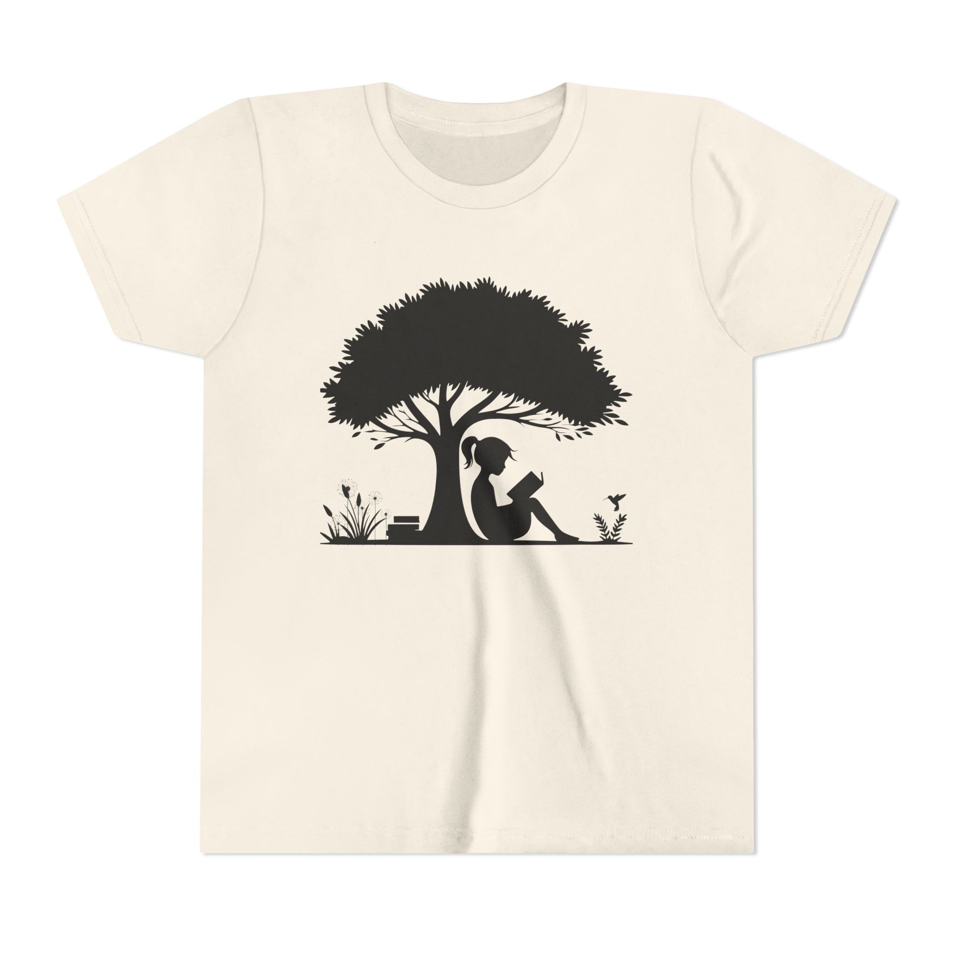 Beige t-shirt with a black silhouette of a girl under a tree reading a book.