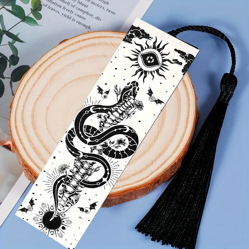 Decorative bookmark with snake and sun design on a wooden surface