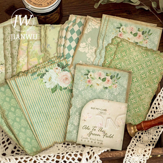 A collection of vintage floral note papers with various floral patterns in shades of green, blue, and white, displayed on a lace doily.